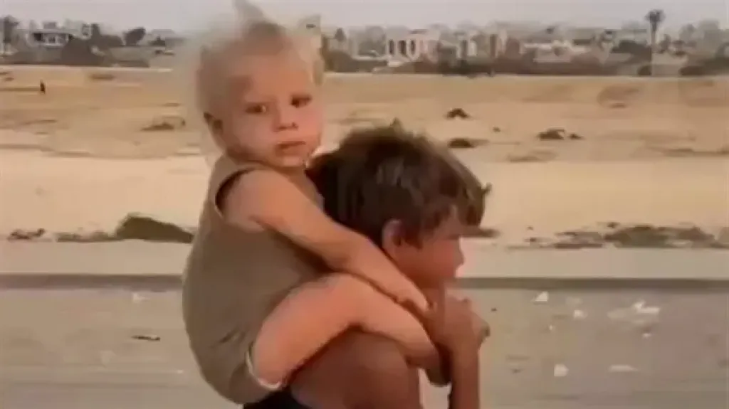 طفل فلسطيني صغير يحمل شقيقه